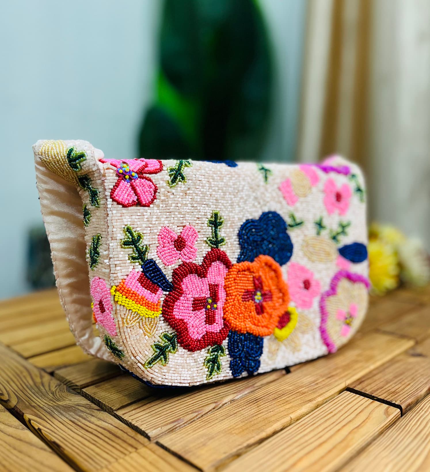 Colorful hand-beaded shoulder bag featuring vibrant floral patterns, set against a light background, showcasing Zara's